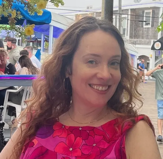 An image of a woman with long brown hair and a smile in Cherry Grove, Fire Island